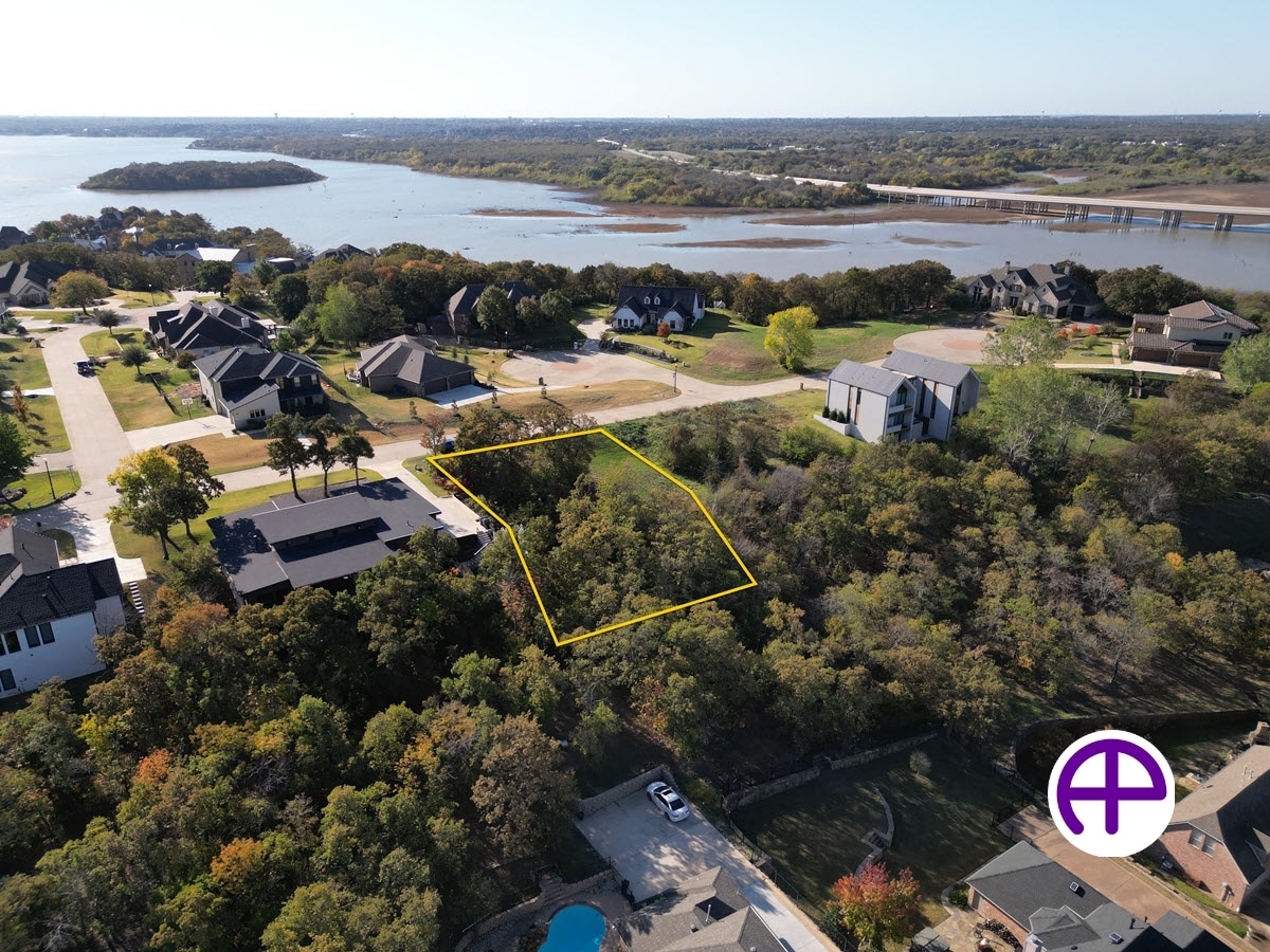 Aerial photo of a vacant lot with property boundaries near the lake, featuring accuaerialphotos™ and accupropertyboundaries™ services