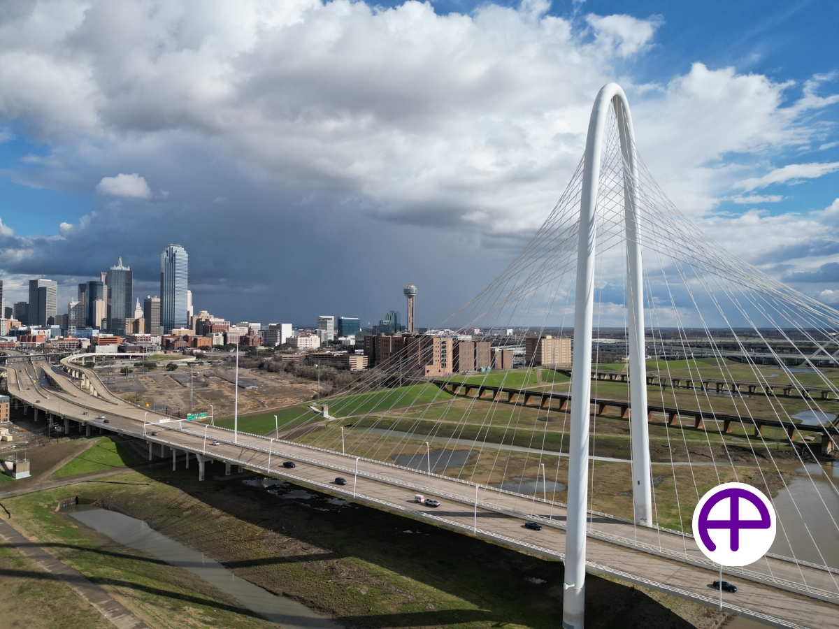 Aerial view of margaret hunt hill bridge with dallas skyline in the background captured by accudrones™, accuaerialphotos™, and accuaerialskyline™.