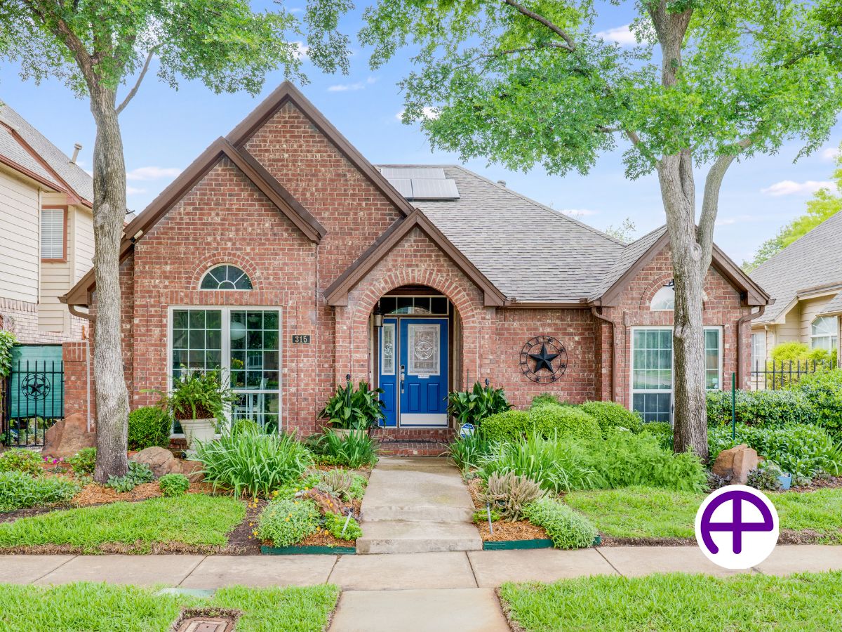 Exterior photo of single-story home with lush shrubs and lawn