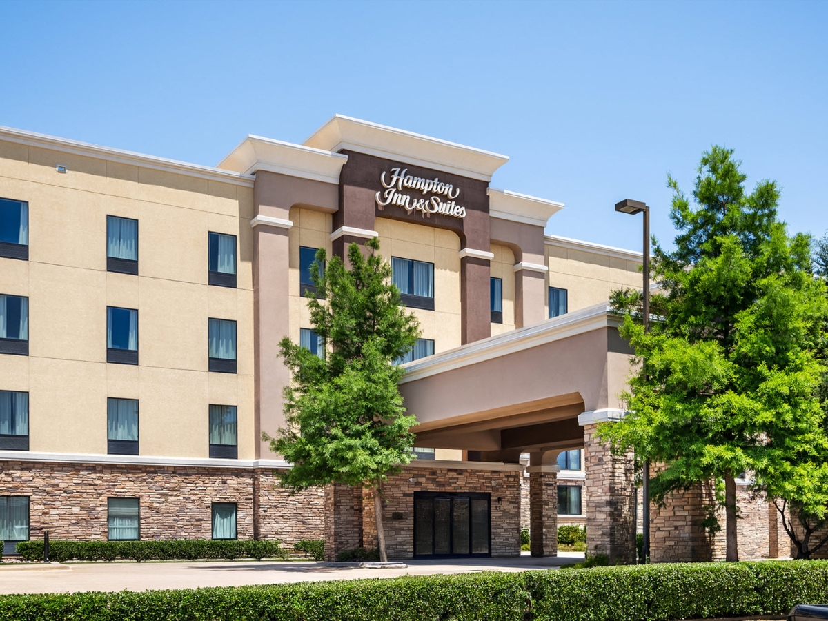 Exterior view of a four-story hotel captured with accucommercialrealestatephotography by a certified professional photographer (cpp).