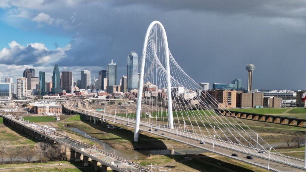 Aerial photo of the iconic margaret hunt hill bridge in dallas, texas, under a stormy afternoon sky, highlighting acculocations' expertise in dfw.