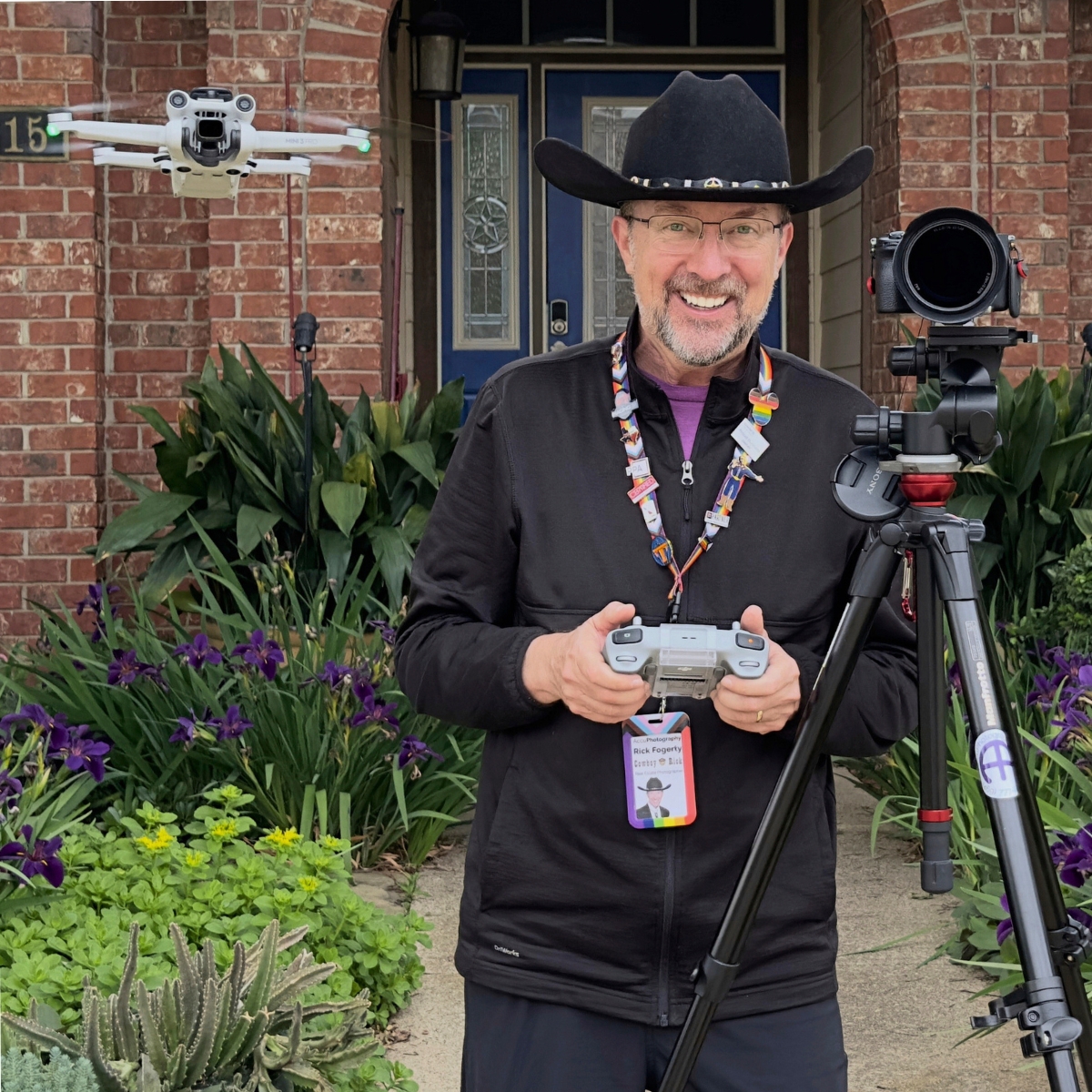 Rick a. Fogerty (cowboy rick) wearing a black cowboy hat holding a drone and camera, founder of accuphotography and certified real estate photographer in dallas, tx.