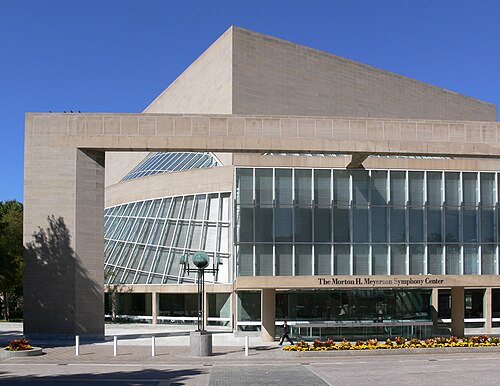 Exterior architectural photo of the morton h. Meyerson symphony center in dallas, texas, featuring glass facades and stone columns.